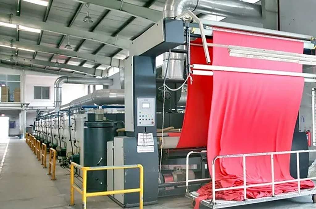 Evaluating textile quality in apparel doesn&rsquo;t just happen when a finished garment is in the hands of a retail buyer. Every step in the knit supply chain offered ways for brands to make sure the material they are considering is right for their garment and their brand. This large textile finishing machine is the last step before bulk material orders are sent to the manufacturers for cut and sewn. Understanding this process is key to sourcing knit fabric for a clothing line.