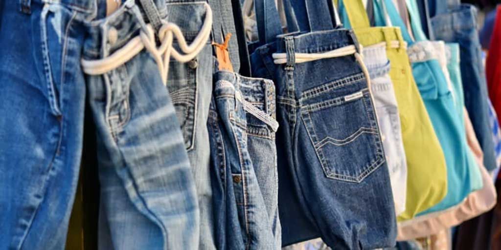 Rack of denim repurposed into upcycled bags, promoting eco-conscious style and sustainability.
